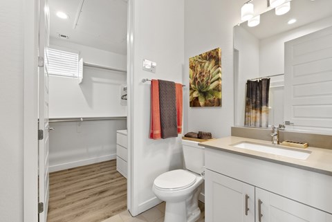 A white bathroom with a toilet, sink, and mirror.
