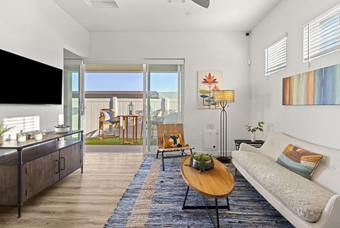 A living room with a couch, a table, and a television.