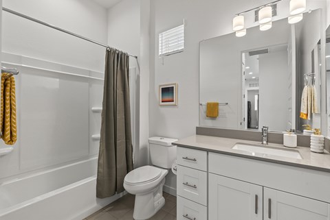 A white bathroom with a toilet, sink, and shower.