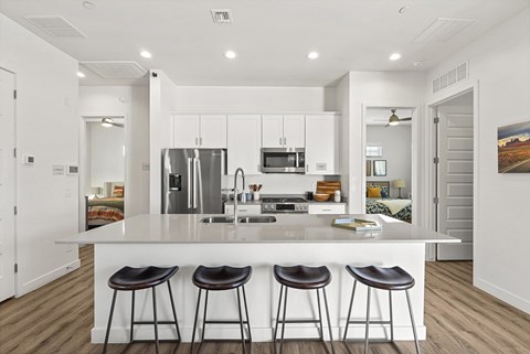 A modern kitchen with white cabinets and a central island.