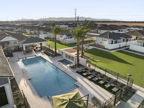 A pool surrounded by a black fence and a green umbrella.