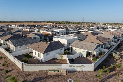A bird's eye view of a residential area with a sign that says "NOW LEASING" in front of a house.