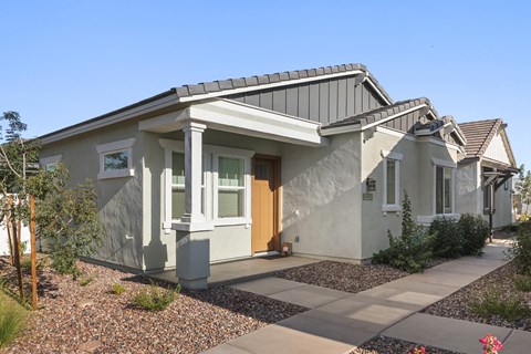 A modern house with a grey roof and white walls.