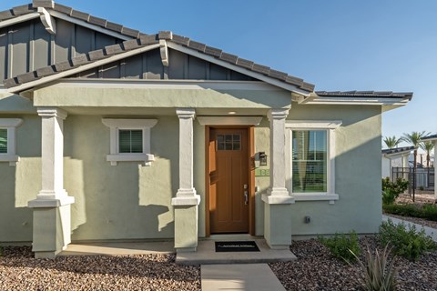 A house with a brown door and white columns.
