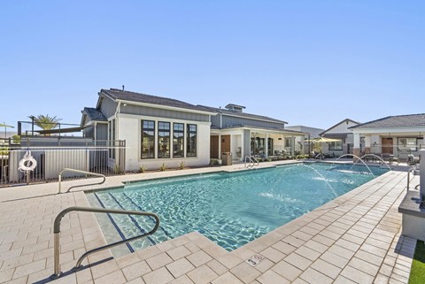 A swimming pool in front of a building with a clear blue sky.