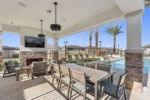 A patio with a table and chairs and a television.