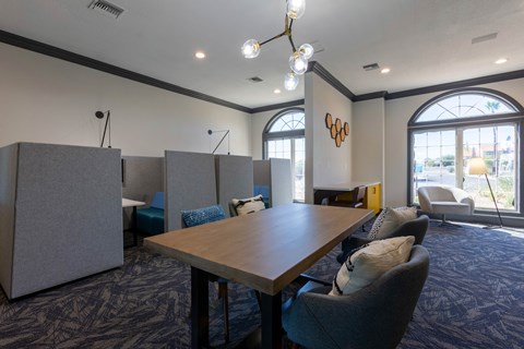 A conference room with a long table, chairs, and a logo on the wall.