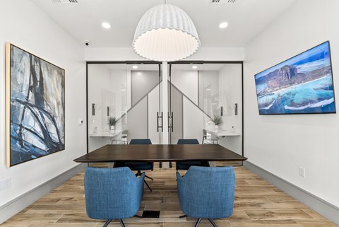 A modern dining room with a wooden table and blue chairs.