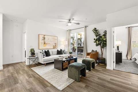 A living room with a white couch, a coffee table, and a painting on the wall.