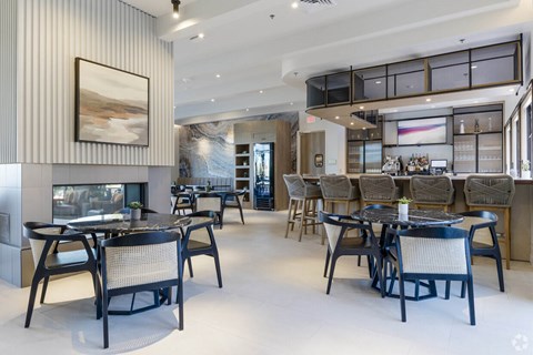 A modern dining room with a fireplace and a painting on the wall.
