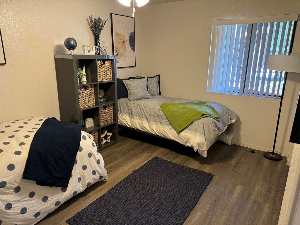 a bedroom with a bed and a nightstand and a window