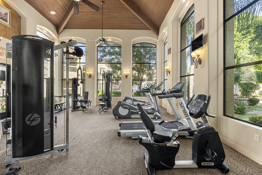 A gym with treadmills, elliptical machines, and other exercise equipment.