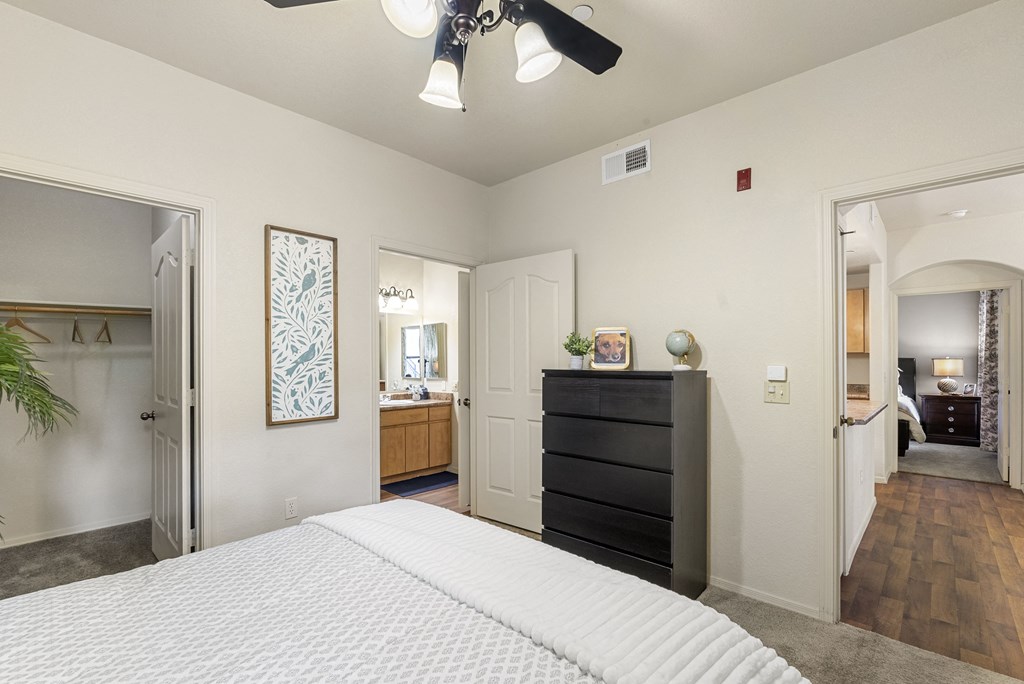 A bedroom with a large bed and a ceiling fan.