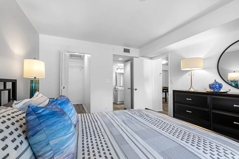 A bedroom with a bed covered in a blue and white striped comforter.