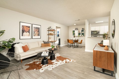 A living room with a white couch, a coffee table, and a rug with a cowhide design.