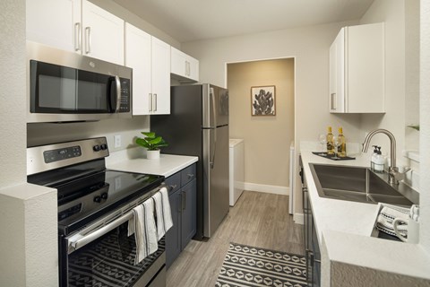 A modern kitchen with a black stove top oven and a black microwave above it.