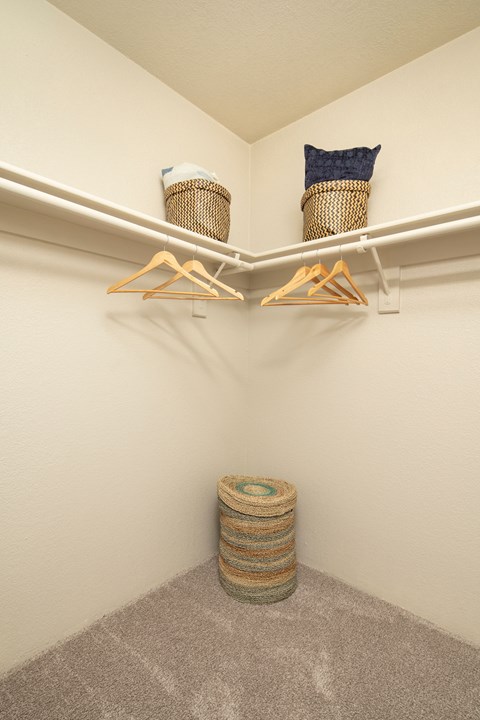 A closet with two shelves and two hangers.