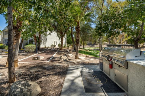 A backyard with a grill and trees.