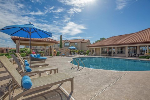 A sunny day at the pool with lounge chairs and umbrellas.