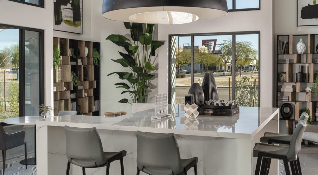 a kitchen with a large white counter top and a large pendant light hanging above it