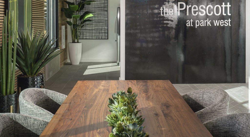 a large wooden table in a room with a blackboard behind it