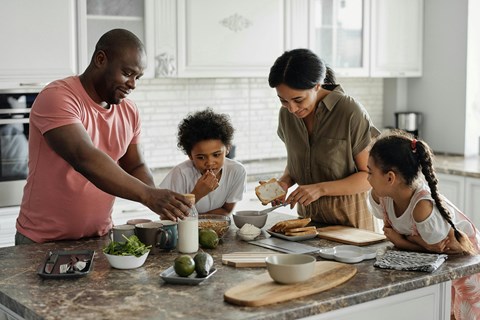 a family gathered around a kitchen counter preparing food