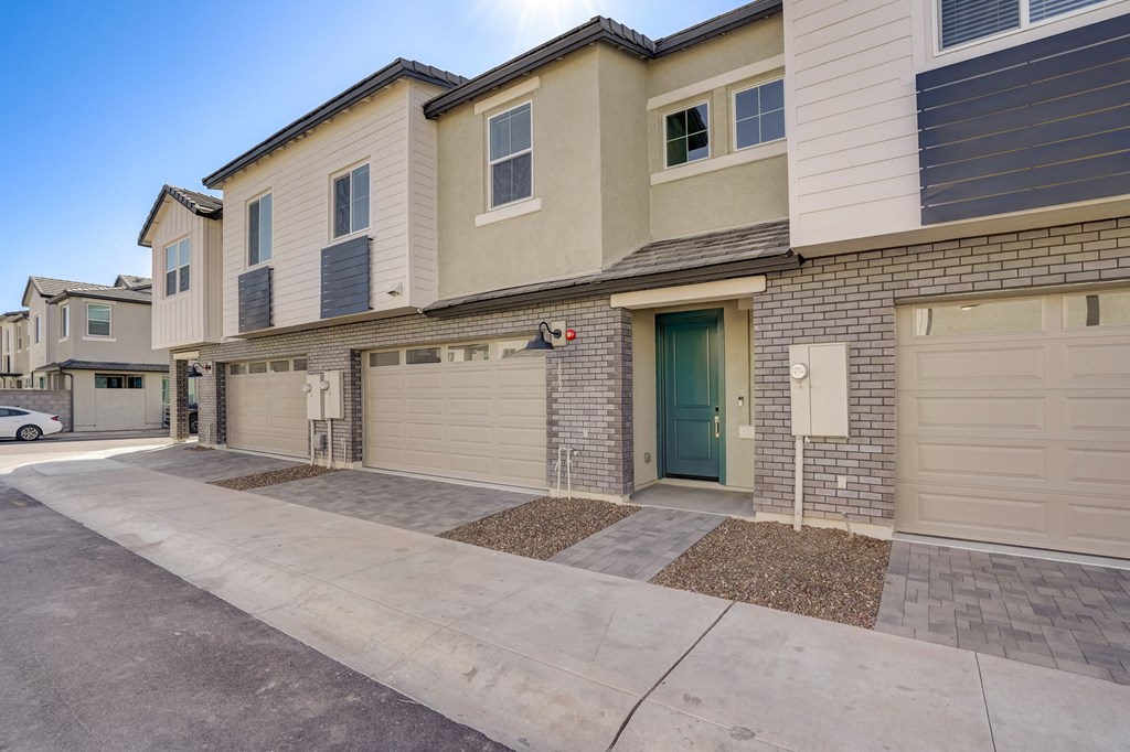 the front of a house with two garages and a sidewalk