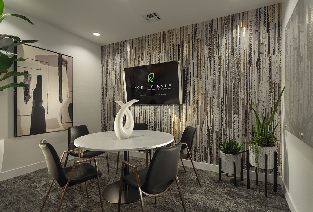 a meeting room with a table and chairs and a tv on the wall