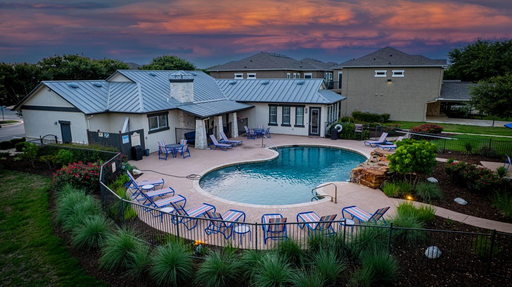 A house with a pool surrounded by a fence.