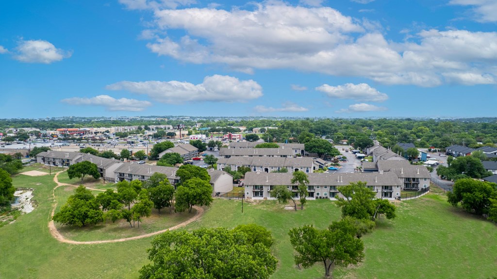 A bird's eye view of a residential area with houses and greenery.