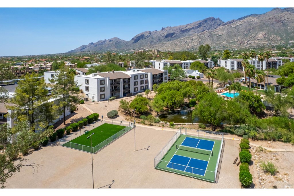 Tennis courts in front of a mountainous backdrop.