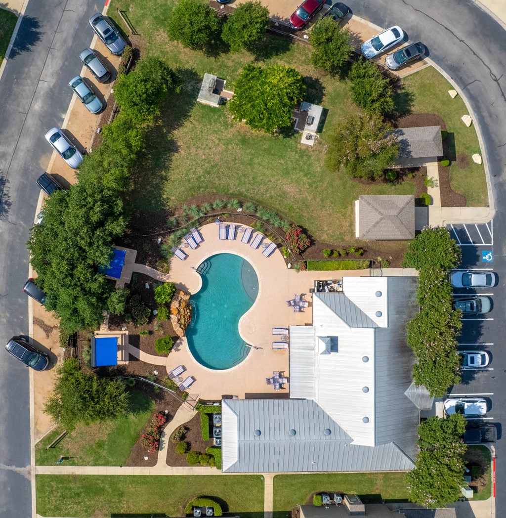 A bird's eye view of a residential area with a swimming pool and a house.