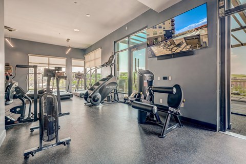 A spacious gym with a variety of equipment including treadmills, stationary bikes, and weight machines.