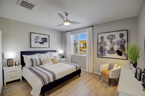 A bedroom with a large bed and a ceiling fan.