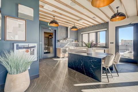 A modern kitchen with a marble countertop and a dining table with chairs.