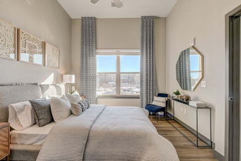 A bedroom with a large bed and a view of the city.