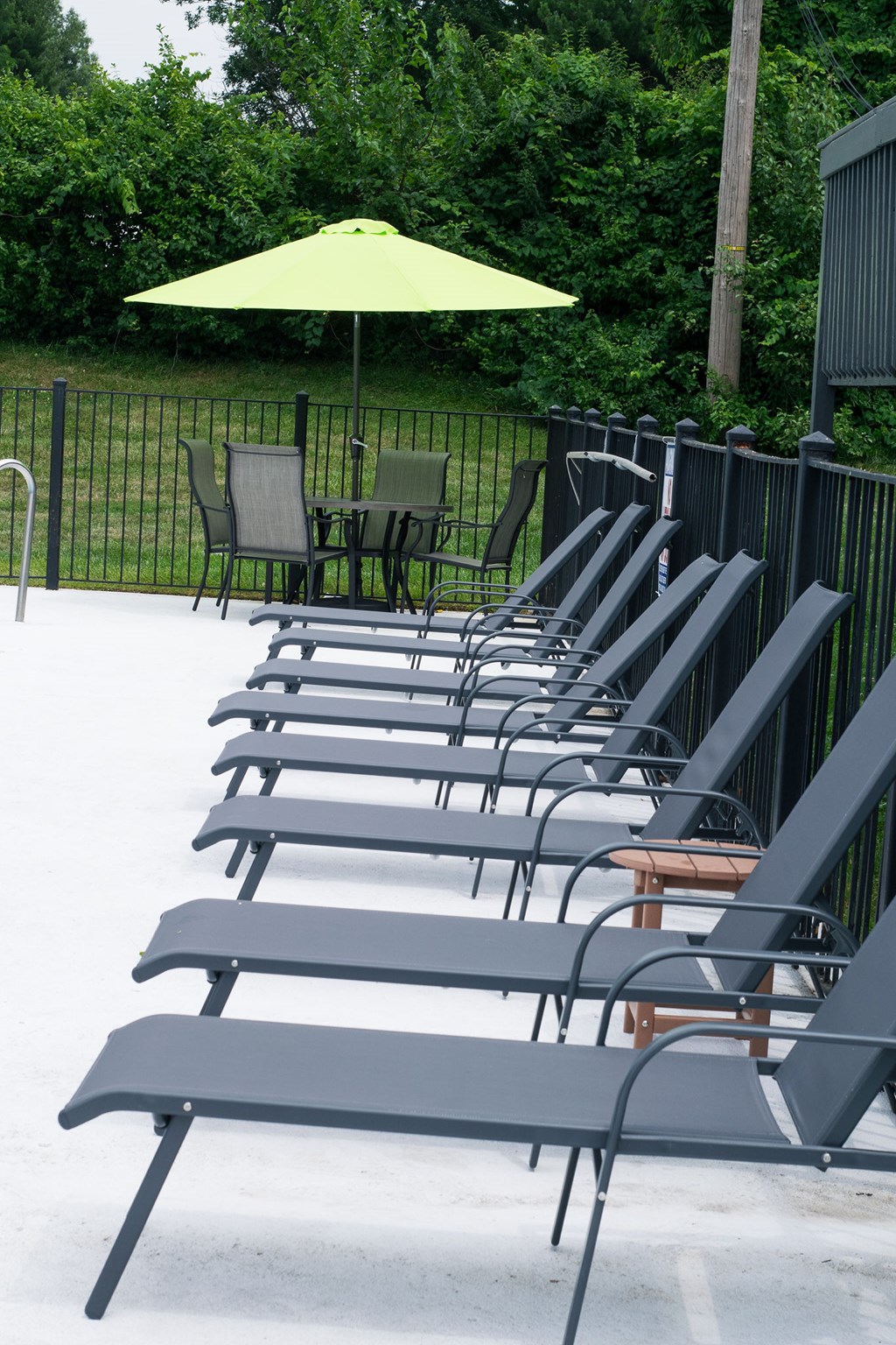 A row of black chairs are lined up on a patio.