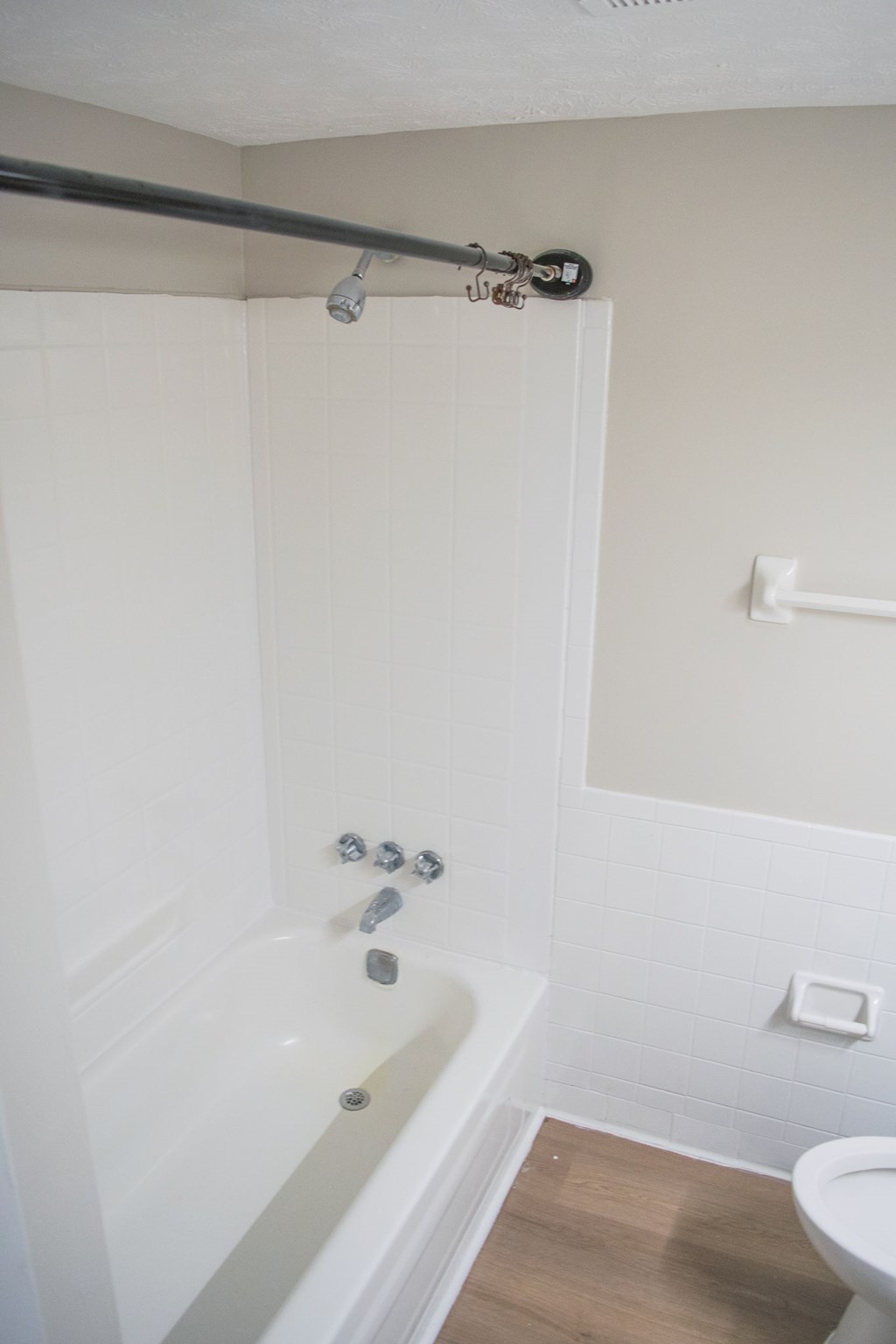 A white bathroom with a tub and toilet.