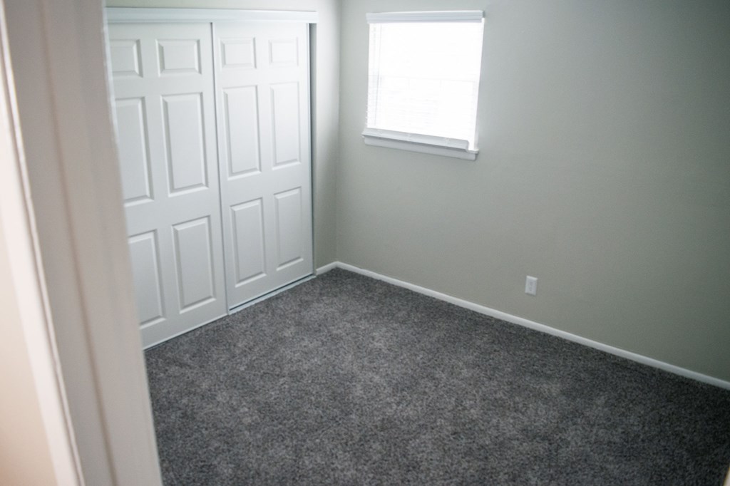 A room with a white door and a window with a white frame.