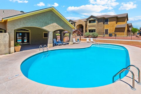 A blue swimming pool in front of a house.