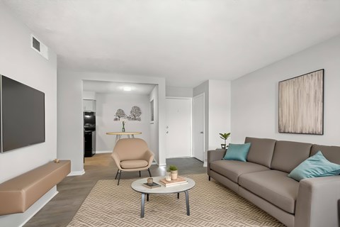 A living room with a grey couch, a brown chair, and a brown bench.