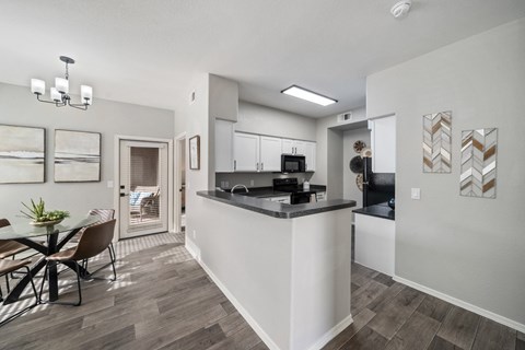 A modern kitchen with a dining table and chairs.