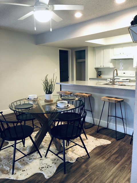 a dining room with a table and chairs in front of a kitchen