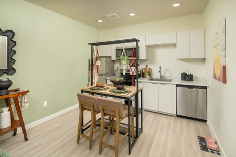 a kitchen with a bar and a table with chairs