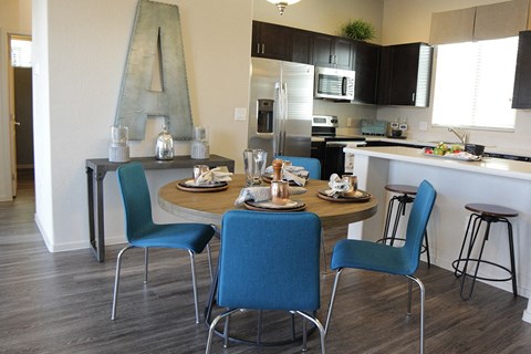 A kitchen with a dining table and chairs.
