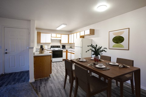 a dining room and kitchen with a wooden table and chairs