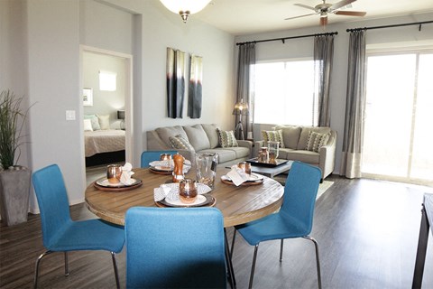 A dining room with a round table and blue chairs.