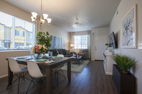 a living room and dining room with a table and chairs
