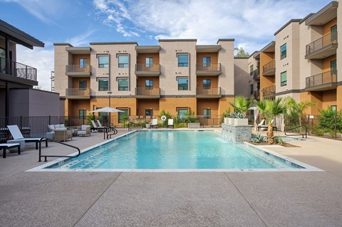 A large swimming pool in front of apartment buildings.
