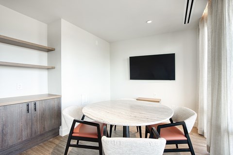 A modern dining room with a round table and chairs.